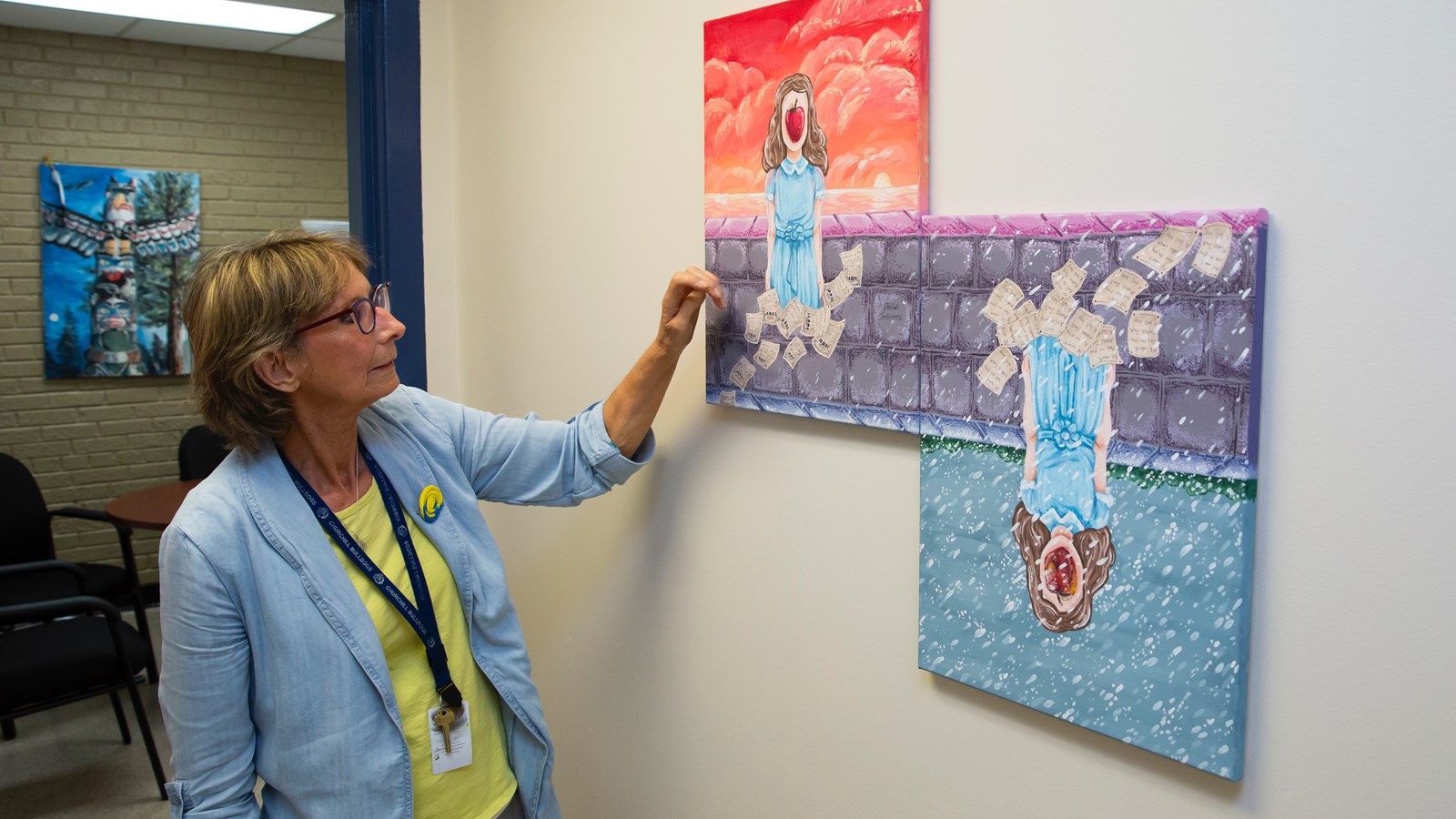 Ms. Pisichko points out a student-made painting that adorns the Churchill main offices.